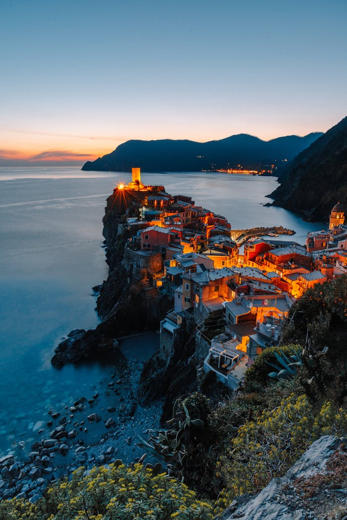 expertise-01 Stunning sunset view of Vernazza village illuminating the coast in Cinque Terre, Italy.